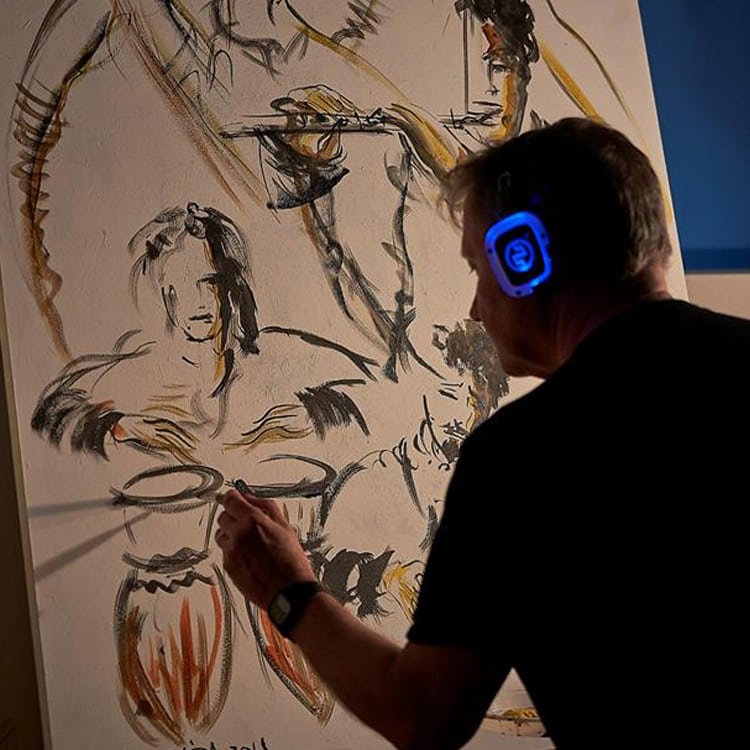 live-painting Kunstenaar aan het live painten met een blauwe led draadloze koptelefoon
