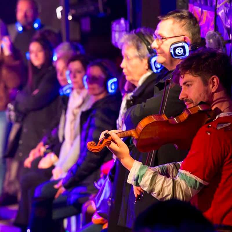silent-opera-vixen Violist en publiek met draadloze koptelefoons bij een koptelefoonopera