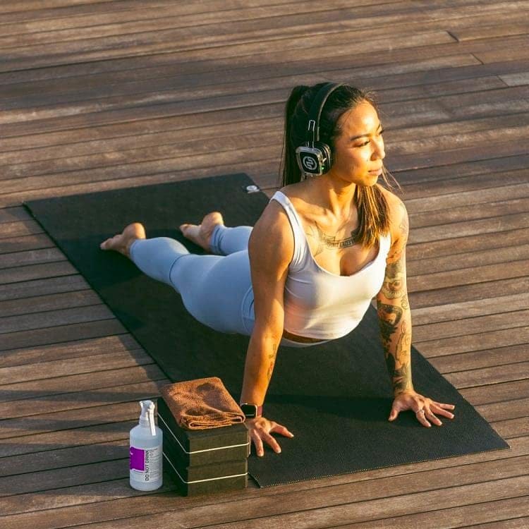 sun-yoga Cobrahouding op een houten platform met draadloze koptelefoon