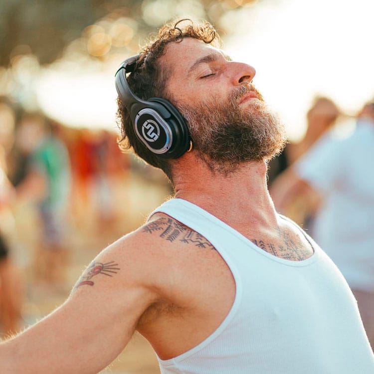 yoga-kalemana Man ademt met gesloten ogen met draadloze koptelefoon tijdens yoga
