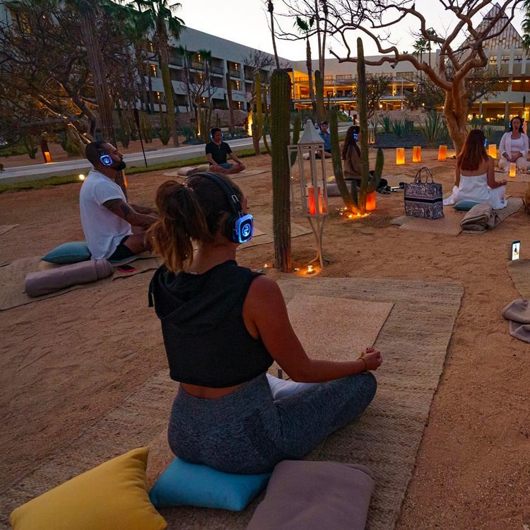 yogasensoriale Zintuiglijke yoga bij zonsondergang met draadloze koptelefoons en kaarsen