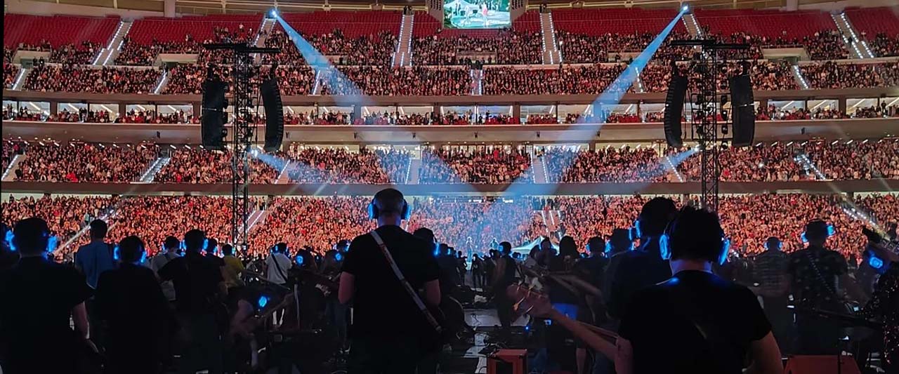 chi-siamo-silentsystem Concert in een arena met publiek dat Silentsystem koptelefoons draagt