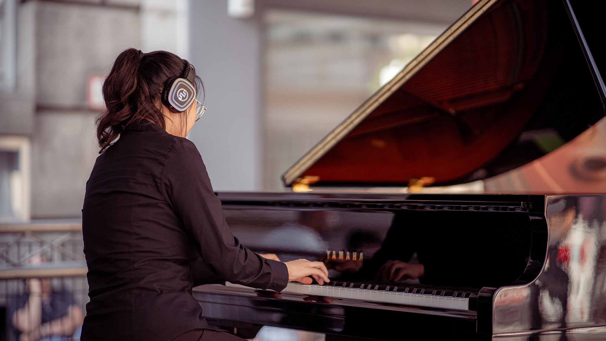 Pianista con pianoforte Yamaha Silent e cuffie wireless Silentsystem Pianoconcerten met draadloze koptelefoons: de complete gids